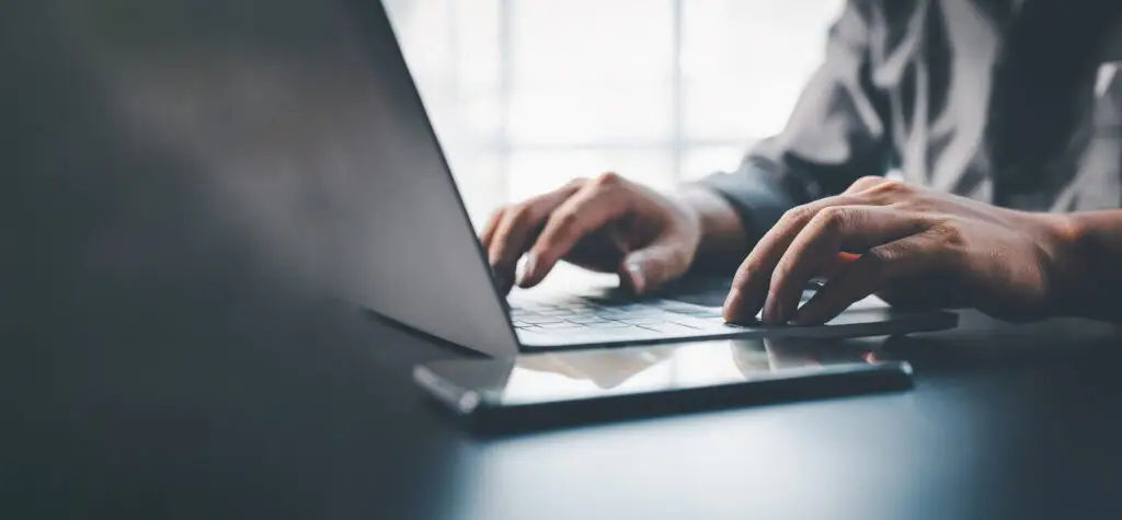 Close up of hands on a laptop.